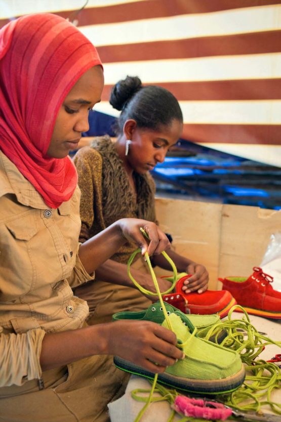Local Zenabwork workers lace up the finished shoes